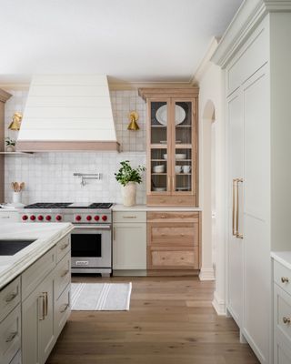 a wood and cream kitchen with a red knobbed range cooker