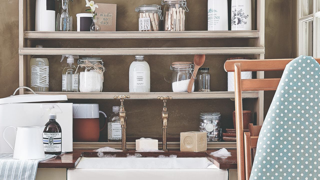 A sink with a shelf of cleaning products and an ironing board