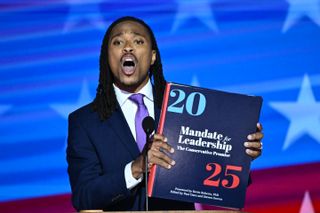 Pennsylvania State Representative Malcolm Kenyatta speaks as he holds a copy of the Heritage Foundation's "Mandate for Leadership," a major component of the "Project 2025" political initiative, on the second day of the Democratic National Convention (DNC) at the United Center in Chicago, Illinois, on August 20, 2024.