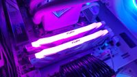 Two DDR5 RAM modules lit up in pink inside a gaming PC