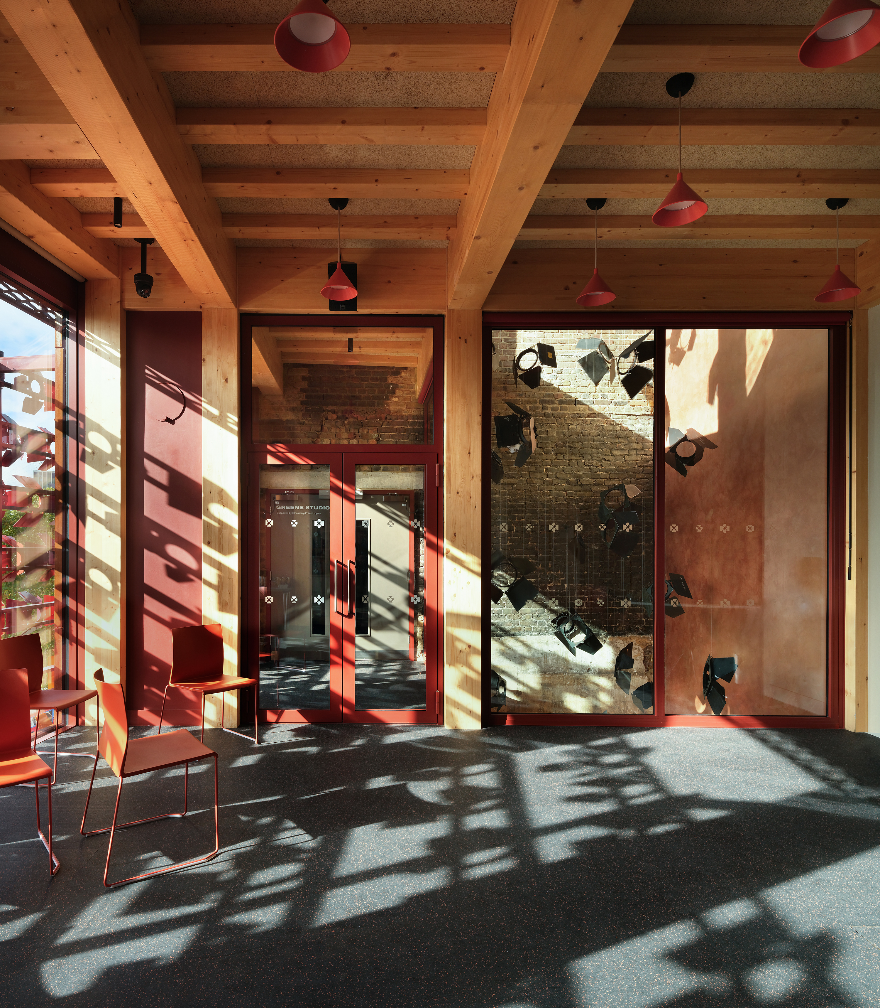 Backstage at the Old Vic, colourful spaces in warm terracota colours in a timber framed building