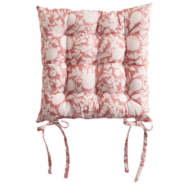 a pink cushion with a floral design, made to be tied onto the seat of a chair