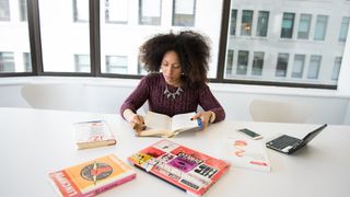 Woman reading book in office