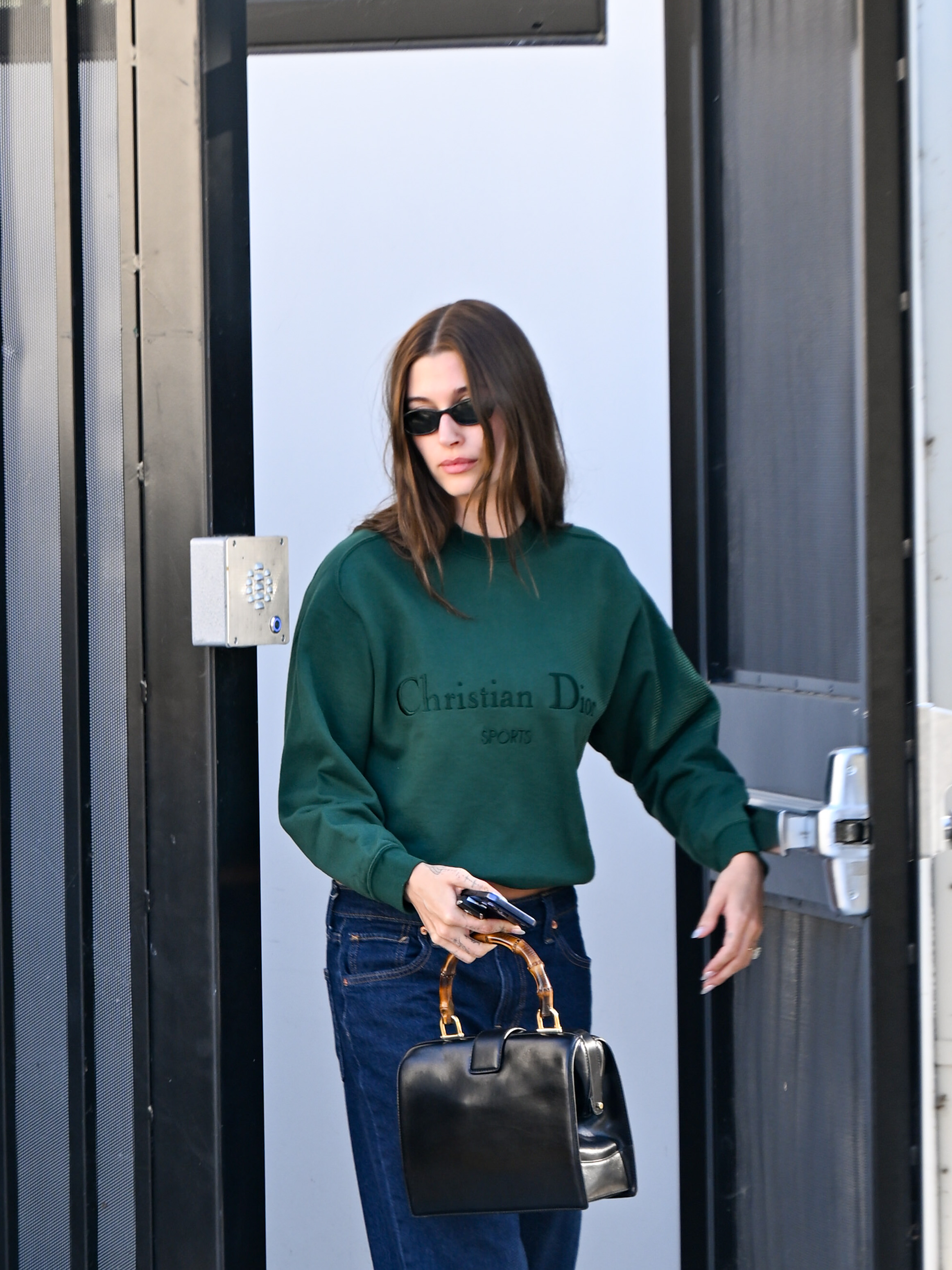 Hailey Bieber styled an oversize Dior sweatshirt with wide-leg jeans and a Dior bowling bag