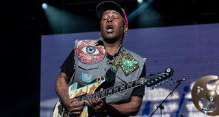 Vernon Reid of Living Colour wears a cut-off work jacket and a ballcap as he takes a solo on his signature Reverend electric guitar, from Rock In Rio 2024