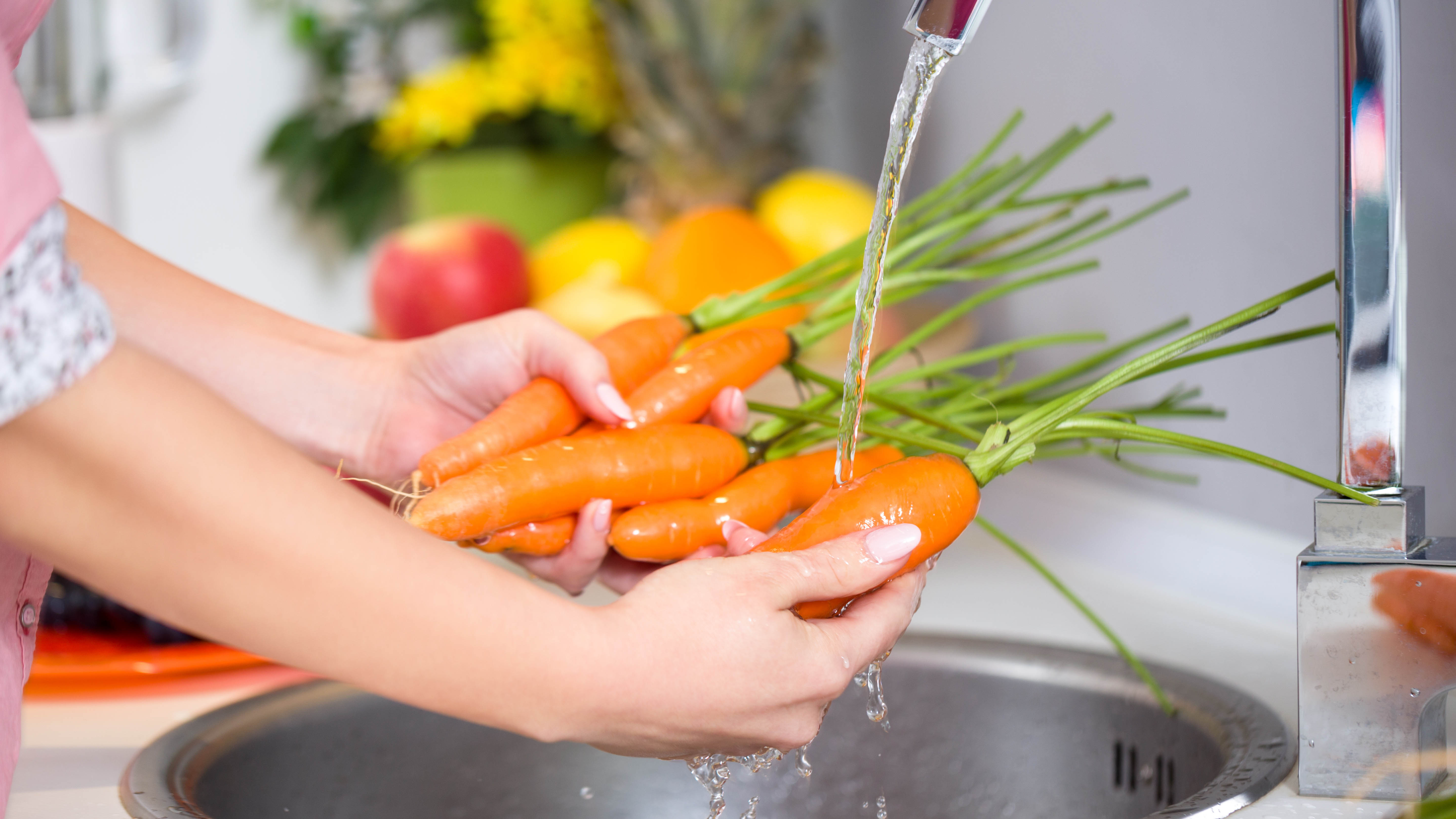Carrots being washed at a sink