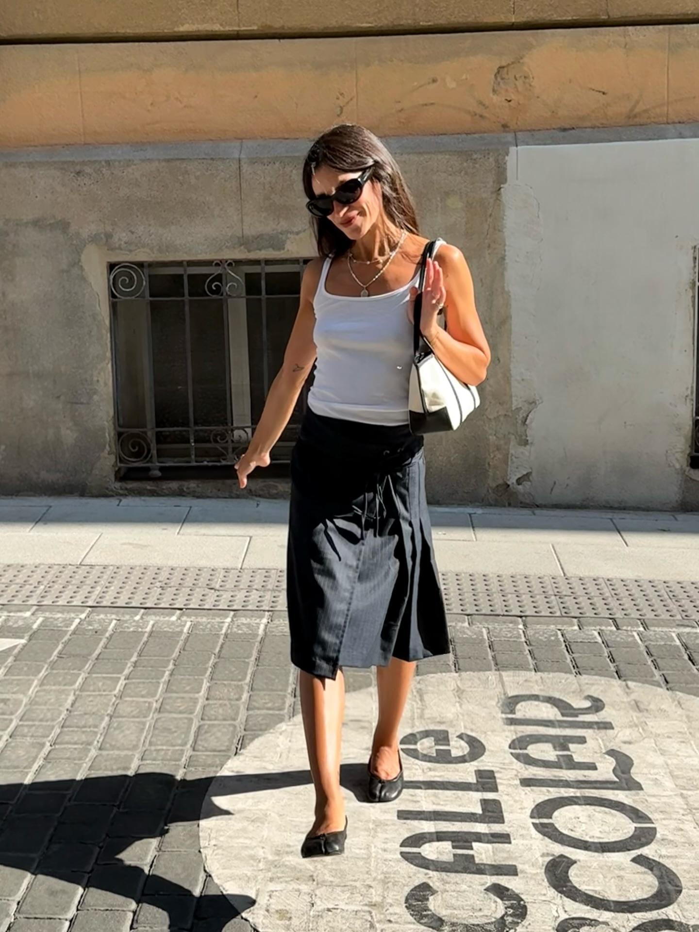 Diana Garcia Urbina wears a white tank top, black midi skirt and ballet flats