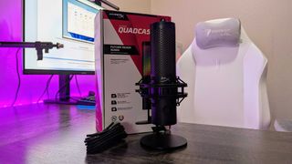 The HyperX QuadCast 2 S on a desk, sitting in front of its retail packaging.