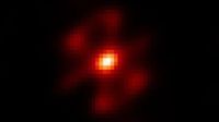 A pixelated image showing a white dot surrounding by orange and red light against a black background