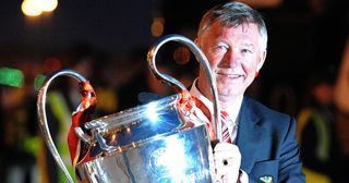 Manchester United manager Alex Ferguson holds the Champions League trophy on May 22, 2008 as he returns to Manchester Airport from Moscow after beating Chelsea on May 21 in the UEFA Champions league final, Manchester north-west England.