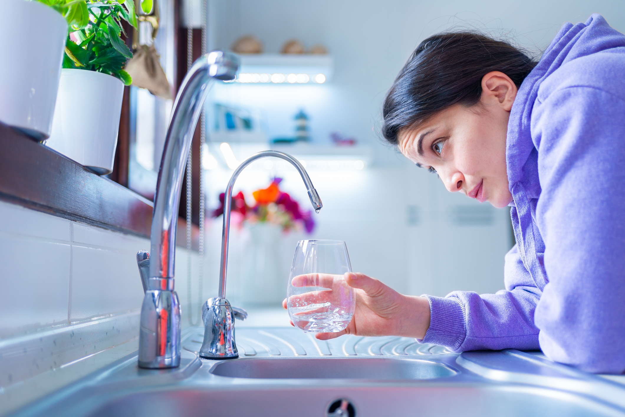 Woman looking a tap with no water coming out