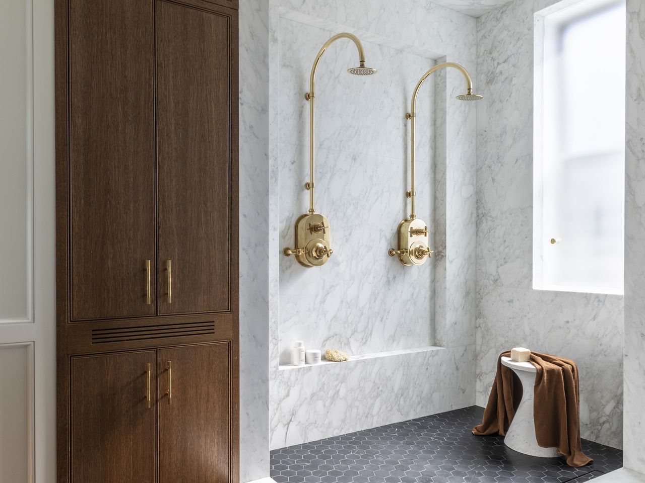 brass double shower in marble shower