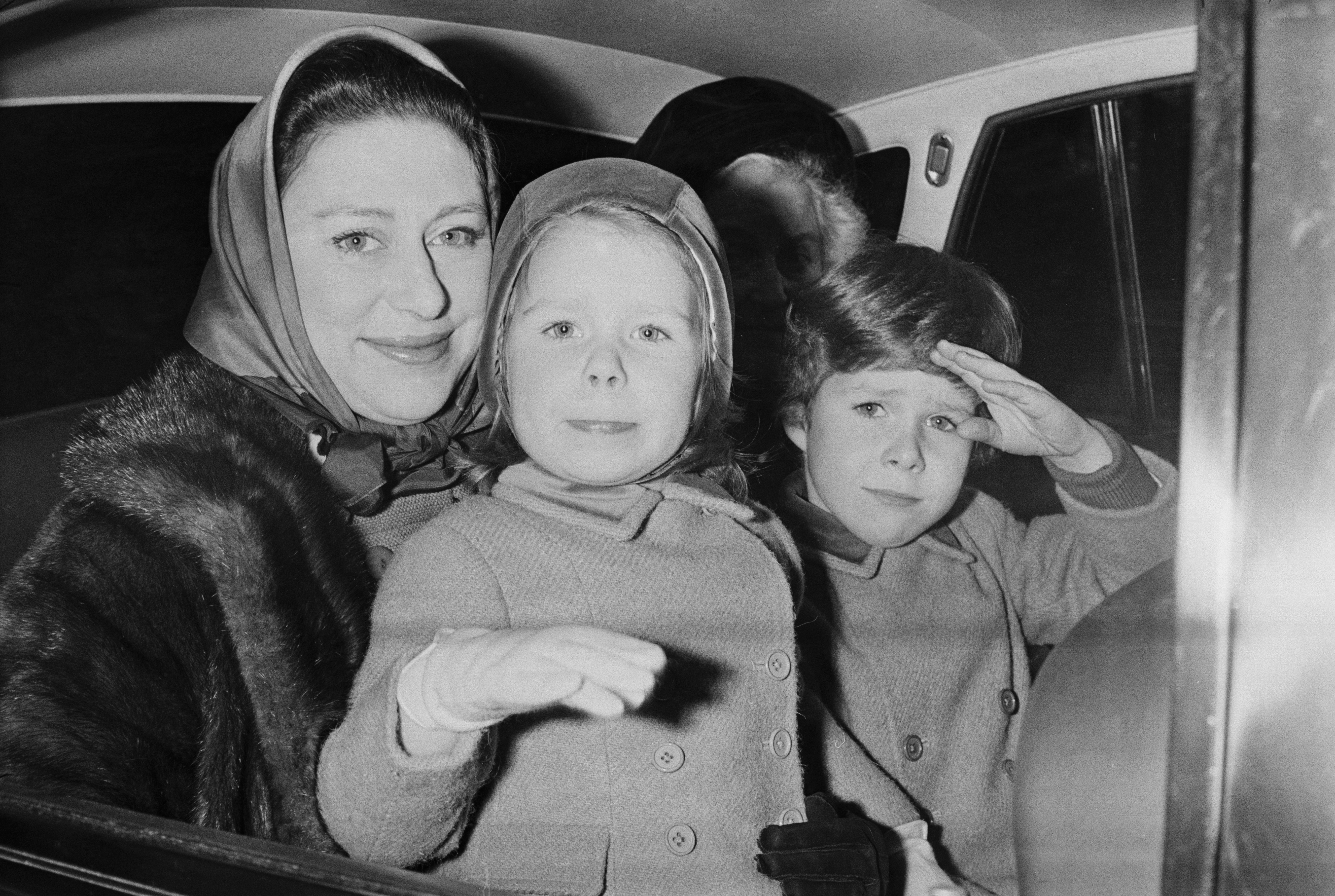Princess Margaret wearing a head scarf sitting in a car with her kids David and Sarah