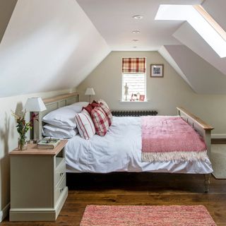 attic bedroom with white wall wooden floor and white bed