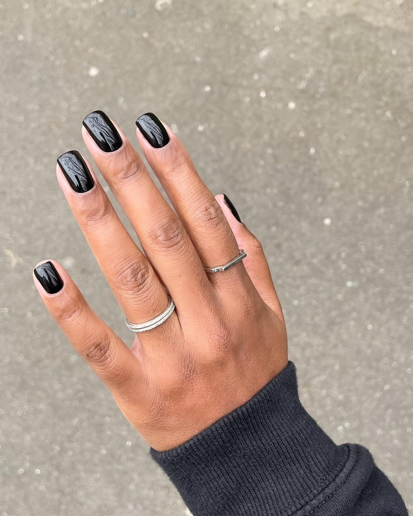 Glossy black neutral nail color.