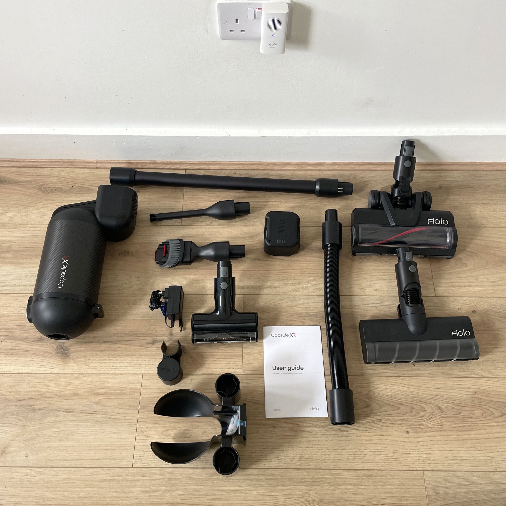 Components of the Halo Capsule XR vacuum laid out on wood-effect flooring