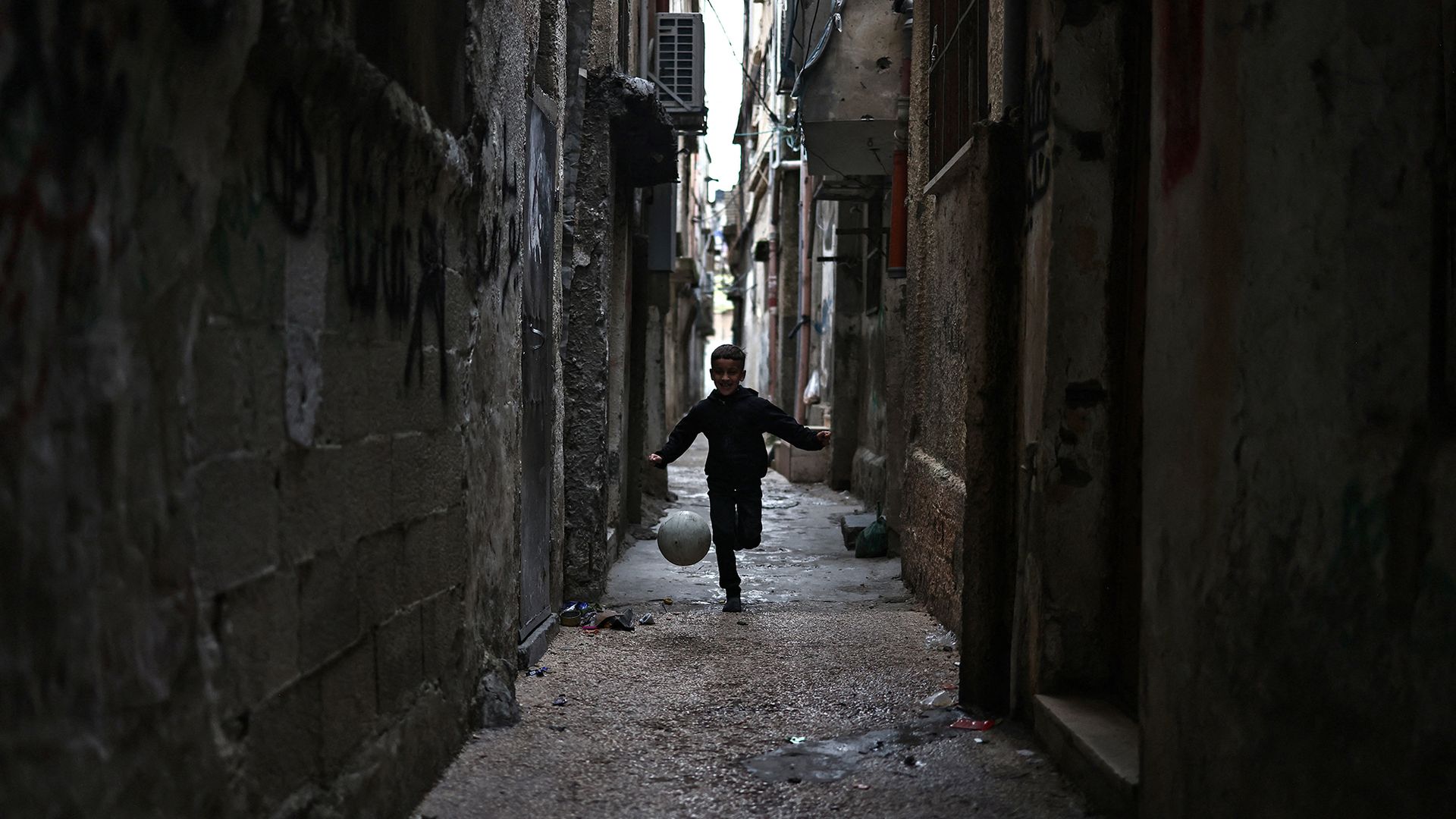 
                                A boy kicks a ball down an alley near the Balata camp for Palestinian refugees in the occupied West Bank
                            