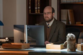 trent sits at a computer at a desk in the paradise season 1 finale