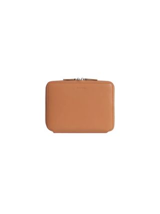 A leather travel kit in terracotta orange.