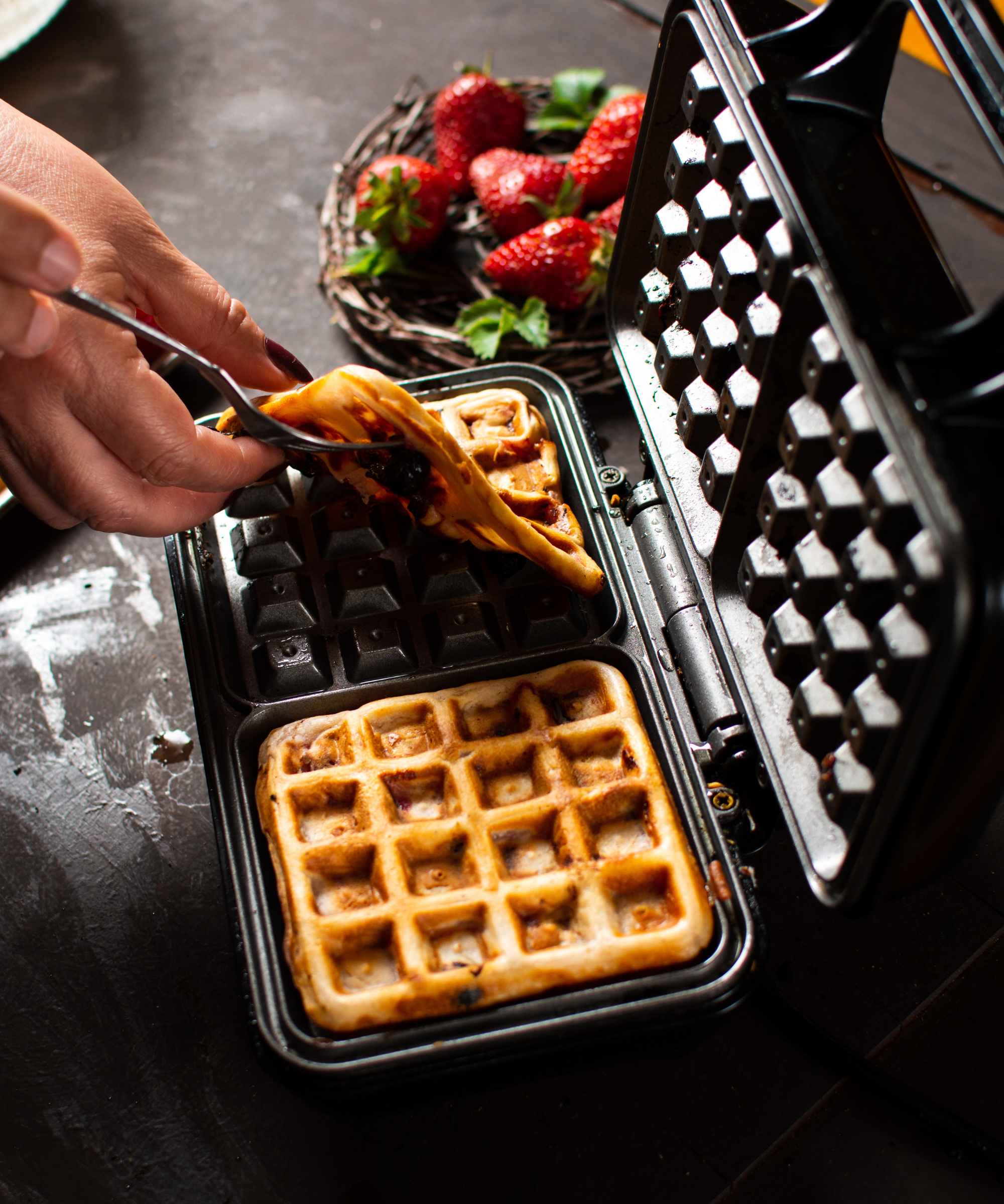 Lifting waffles out of a black, non-stick waffle make
