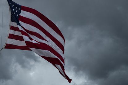 An American flag waves before a storm.