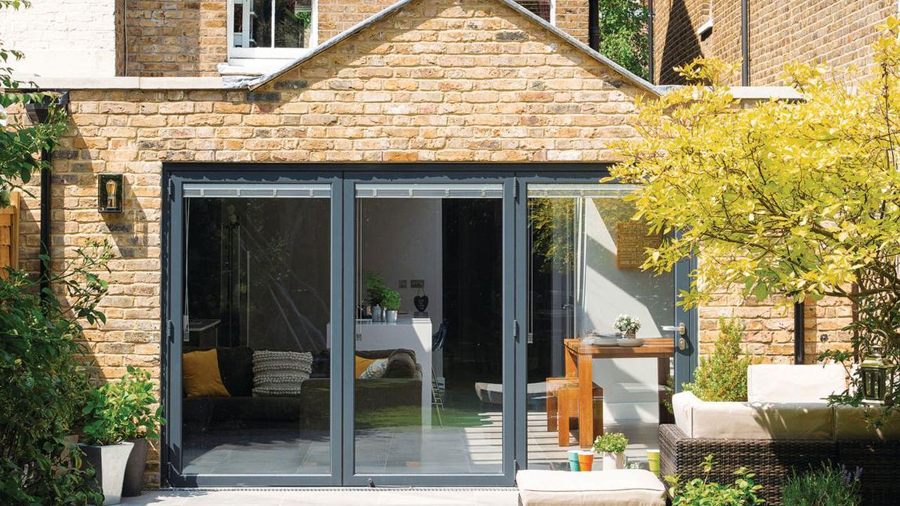 Exterior shot of the rear of a brick house with a single-storey kitchen extension