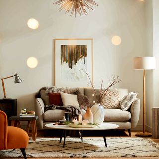 living room with white wall frame on wall grey sofa with designed cushion and standing lamp