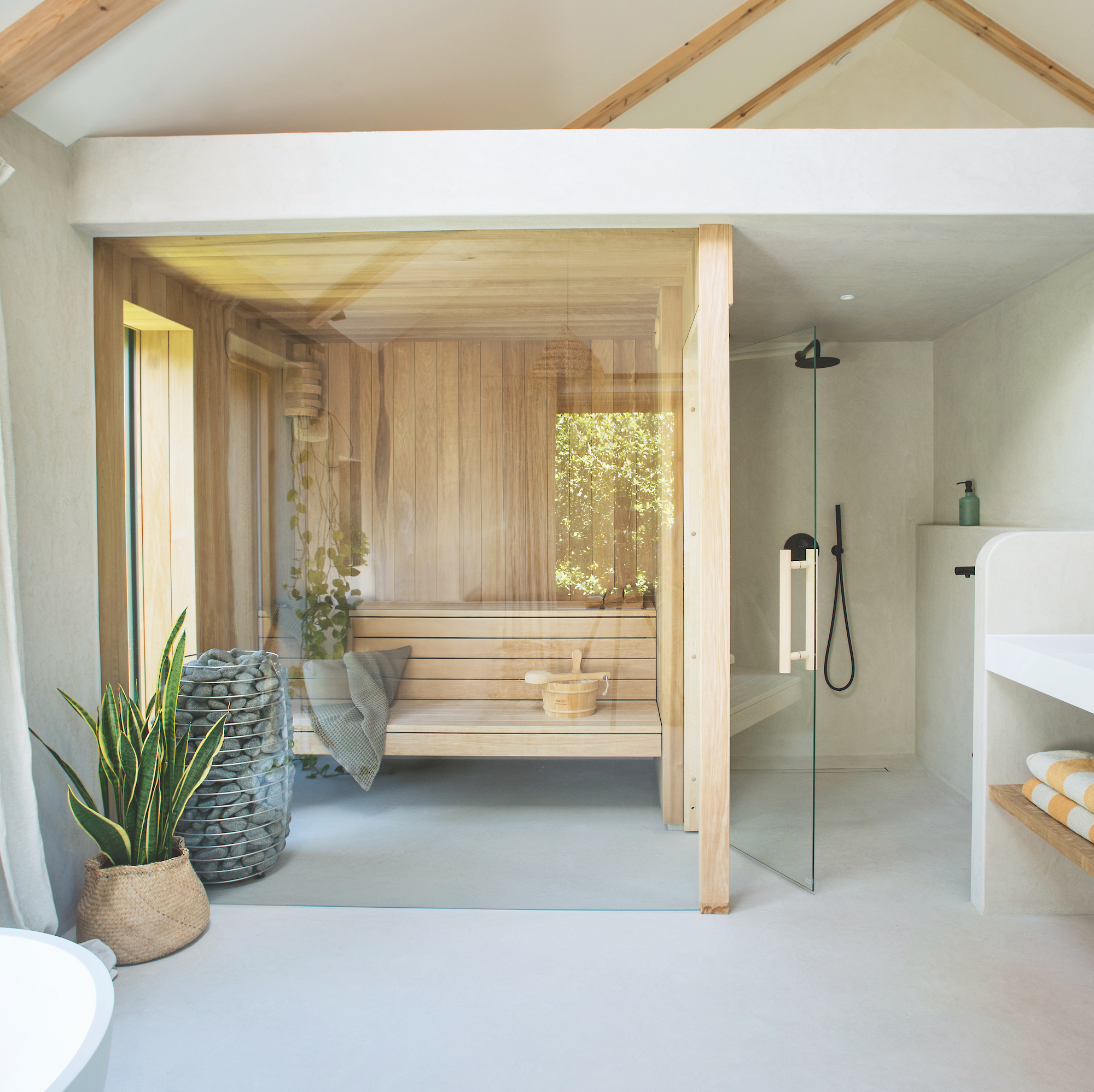 bathroom with contemporary wooden sauna with glazed wall and wooden bench seat, next to white shower enclosure