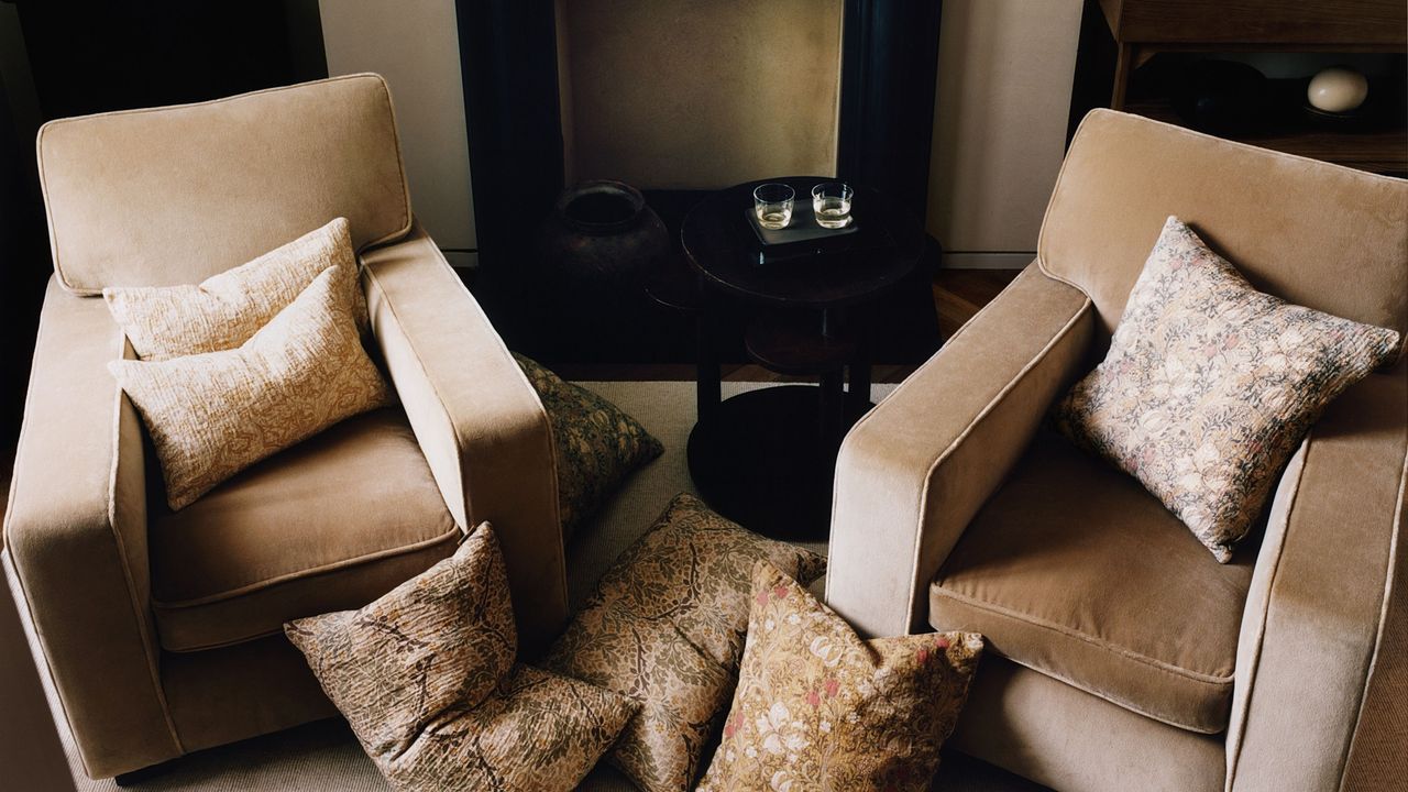 Zara Home x Morris &amp; Co. pillow covers styled in a neutral seating area that features two velvet armchairs