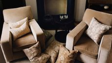 Zara Home x Morris & Co. pillow covers styled in a neutral seating area that features two velvet armchairs