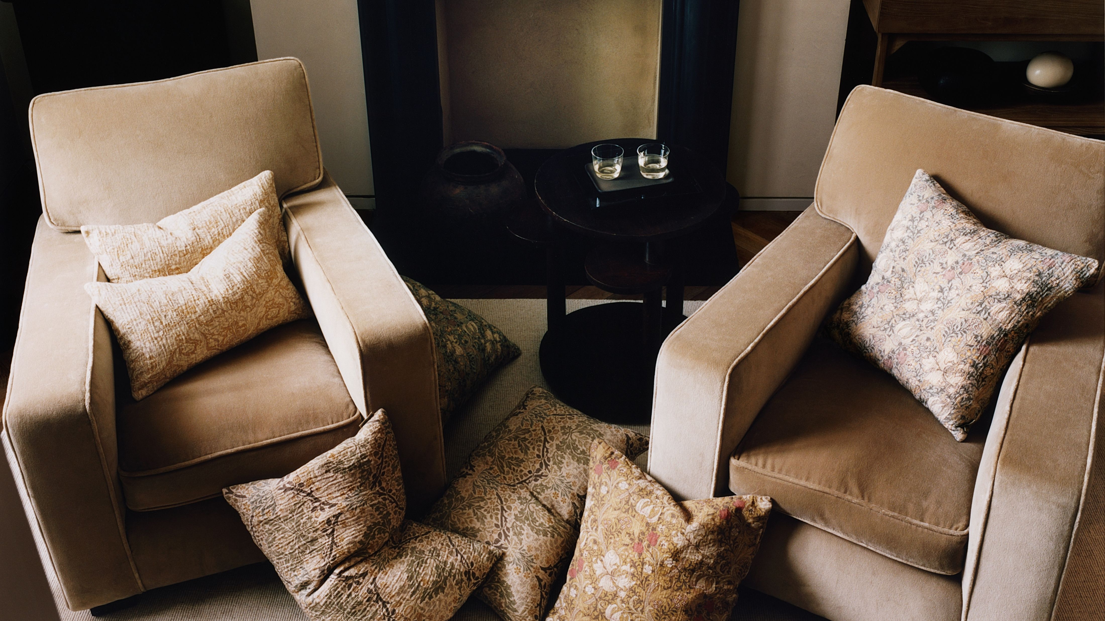 Zara Home x Morris &amp; Co. pillow covers styled in a neutral seating area that features two velvet armchairs