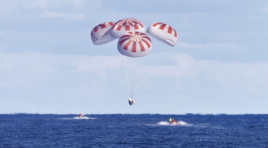 A SpaceX Crew Dragon spacecraft descends under its parachutes at the end of the Demo-1 test flight in March. A test of the parachutes for that spacecraft in April failed when the parachutes didn&#039;t open fully.