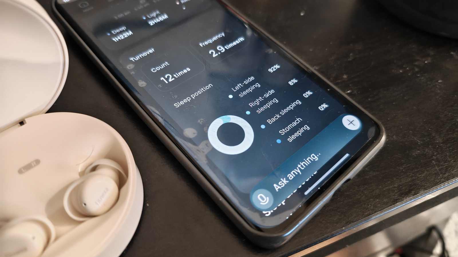 The Fitnexa app on a smartphone next to the SomniPods 3.