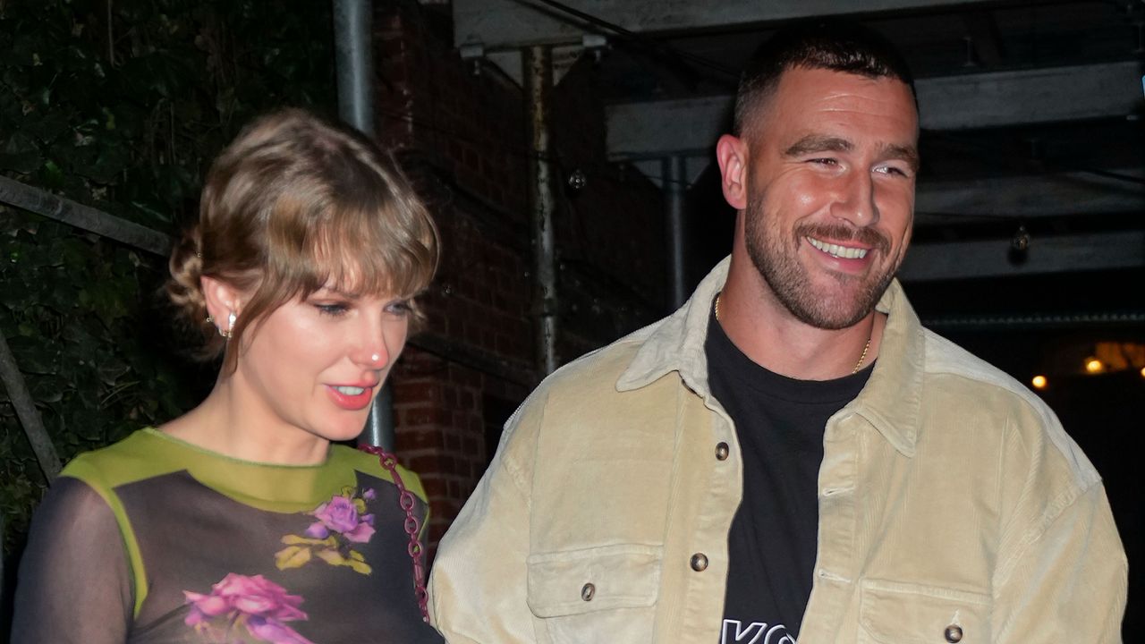 Taylor Swift wears a floral top and has a slightly red nose as she holds hands with boyfriend Travis Kelce