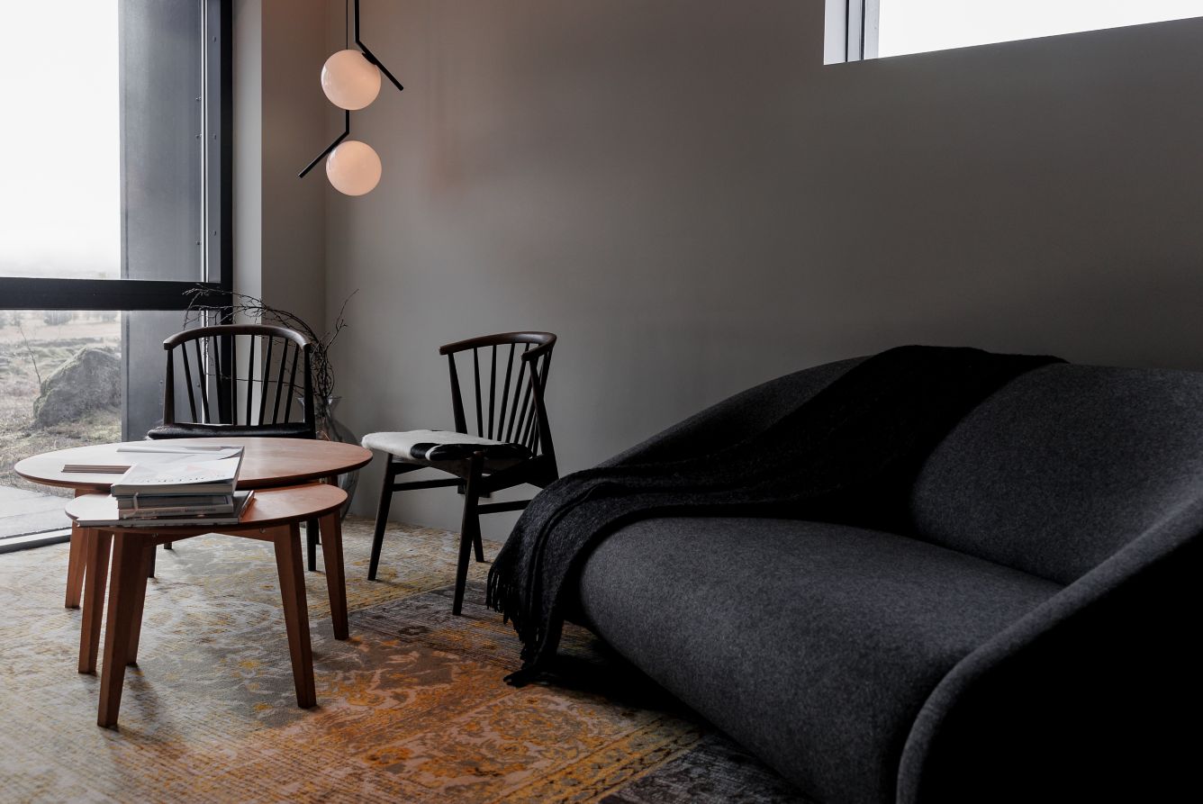 An Icelandic hotel immersed in raw natural landscapes with wild horses boasts brutalist interiors mixing exposed cement, iron, and glass surfaces with western-style design accents.
