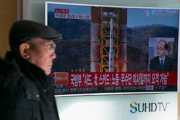 A man walks by a news broadcast about North Korea&amp;#039;s satellite launch.