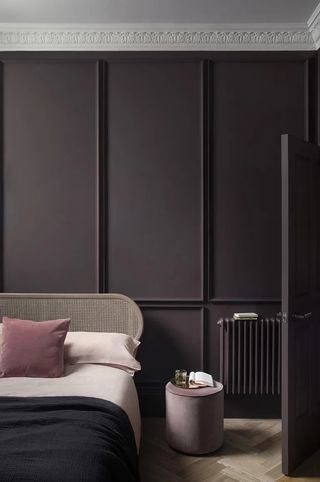A bedroom painted in a shade of eggplant