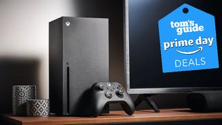 An Xbox Series X and a Controller on a TV stand with our Prime Day deal badge in the top right corner