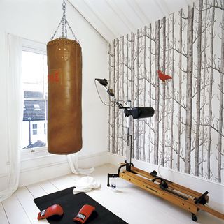 room with white window and punching bag with gloves on floor
