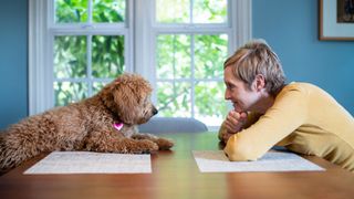 Woman and labradoodle chatting across table