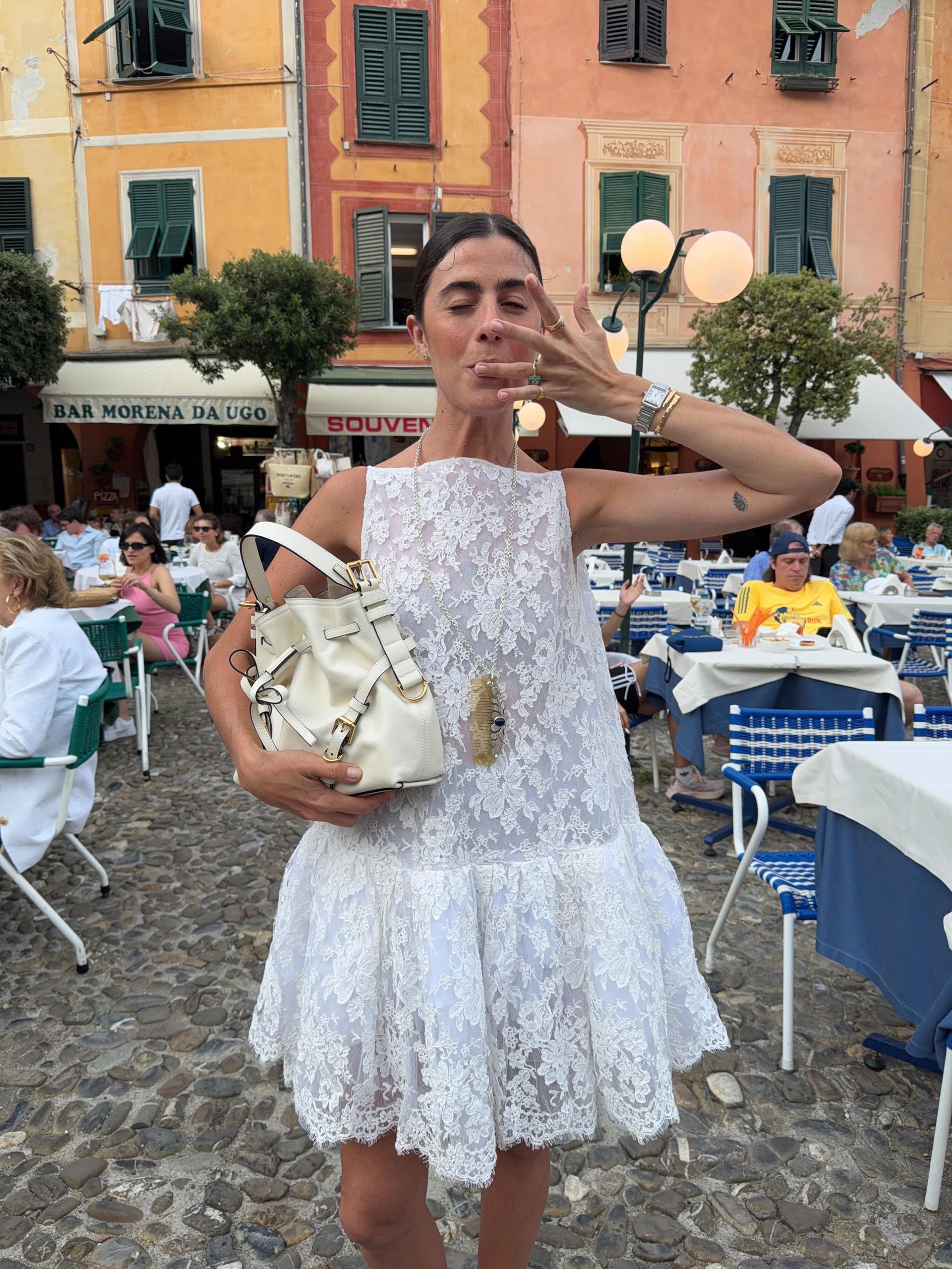 a woman wears a white mini lace dress.