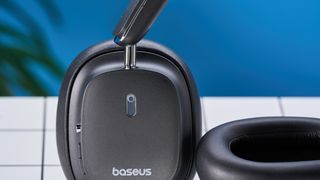 a pair of black baseus bowie 30 max headphones with soft rounded square cups with a blue background