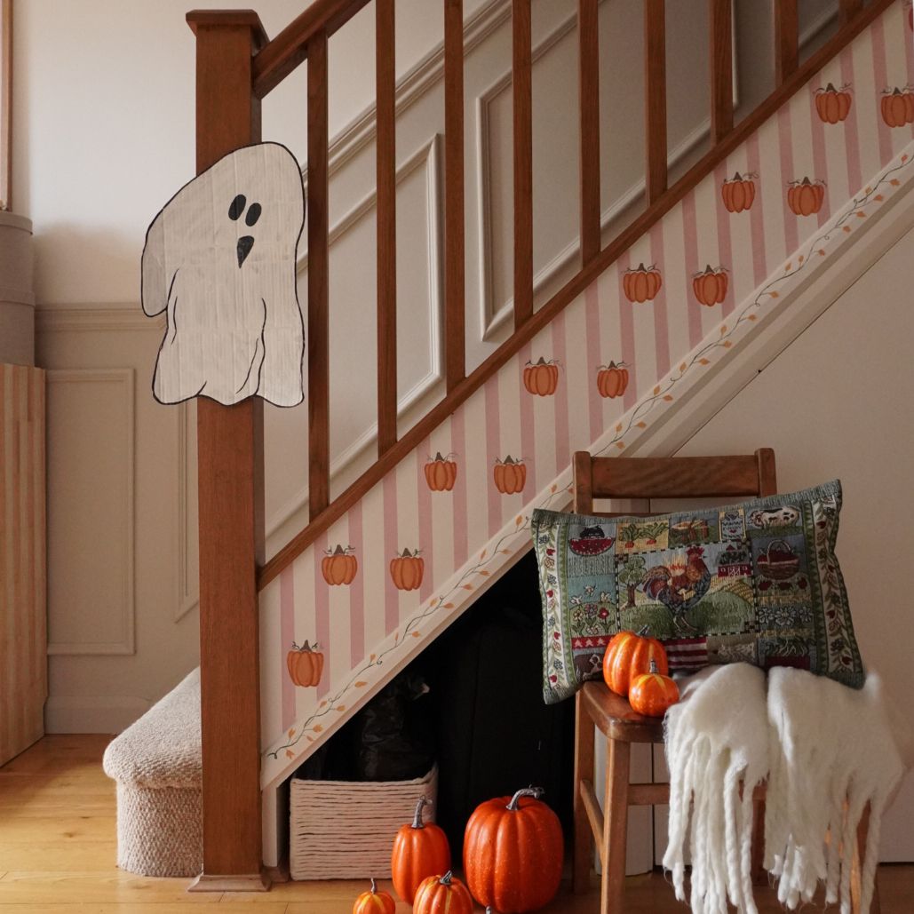 hallway stair rail with pumpkin decorations and a ghost for autumn