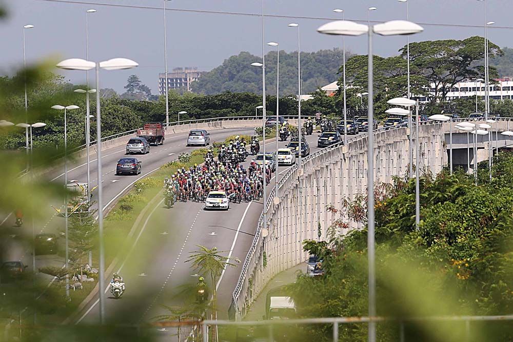 The peloton crosses a bridge