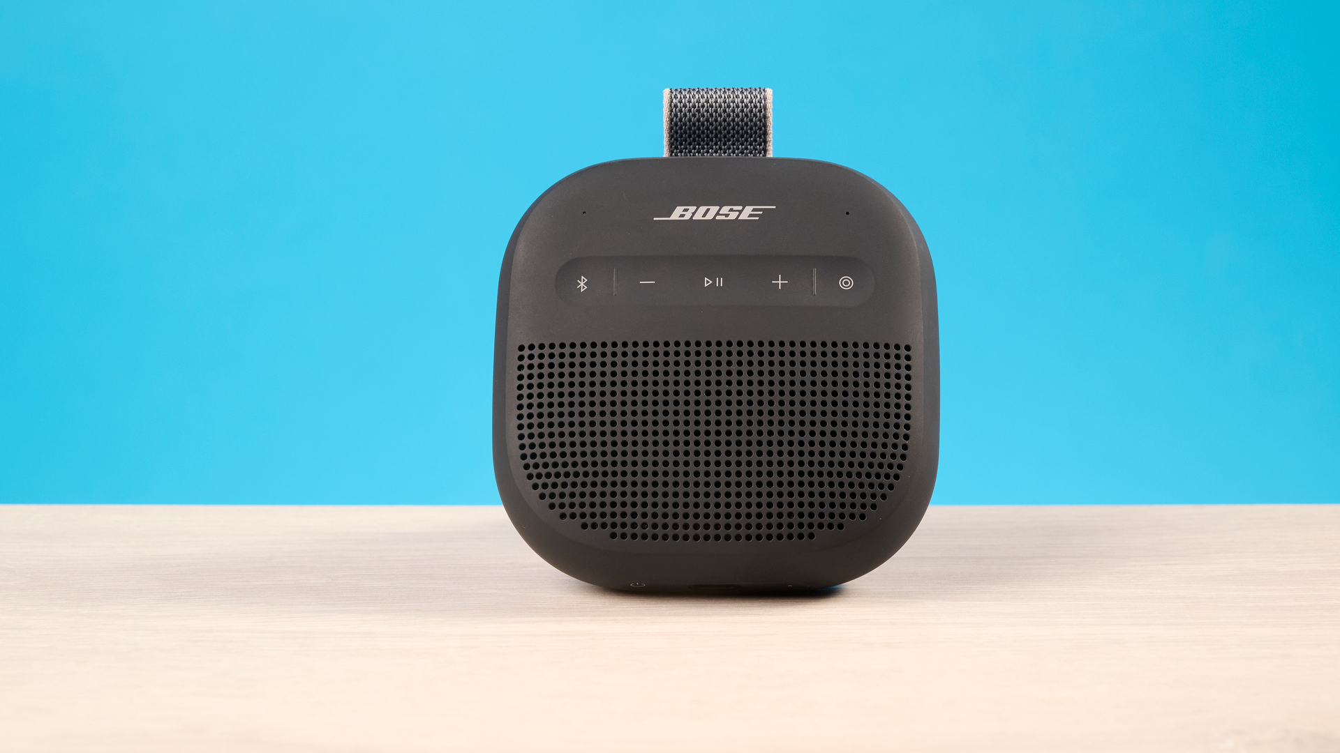 Bose SoundLink Micro 2 in black photographed in front of a blue background