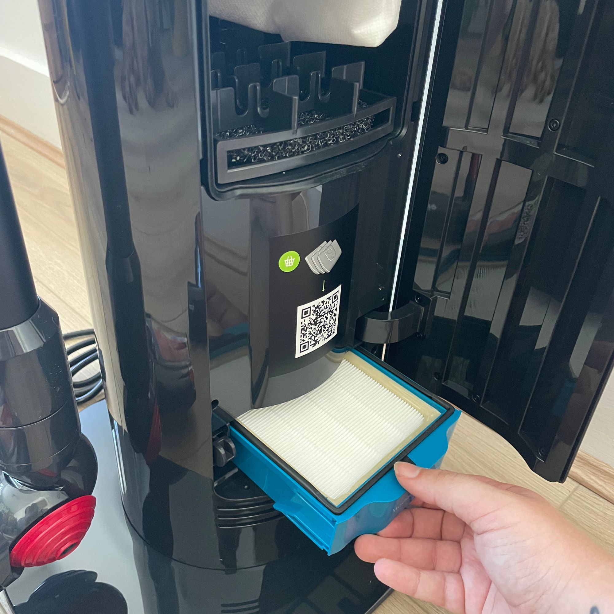 Hand pulling out the filter of the Dyson V10 Konical auto-empty dock