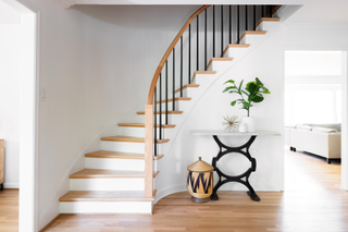 staircase in off-white with white and wood steps, and wood rail with black metal spindles