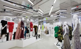 Large room featuring mannequins modelling a range of outfits, with signs describing the outfit and the woman it represented