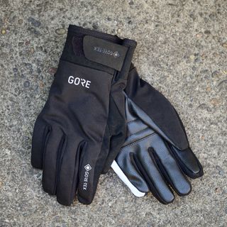 The black Gore Wear C5 gloves on a concrete floor