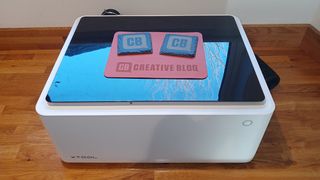 xTool M1 review; a laser cutter that looks like a white box with a transparent lid